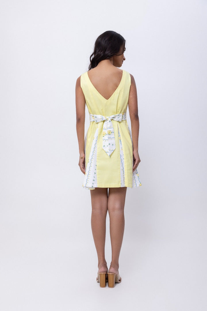 Butter yellow flared mini dress with printed panels and back tie-up bow.